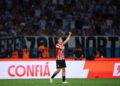 Jogador do Estudiantes comemora em campo diante da torcida no Alt, título e descrição.